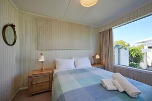 a bedroom with a bed and a large window at Views on Scarborough in Kaikoura