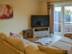 a living room with a couch and a flat screen tv at Autumn Lodge in Mablethorpe