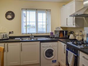 a kitchen with a sink and a washing machine at Autumn Lodge in Mablethorpe