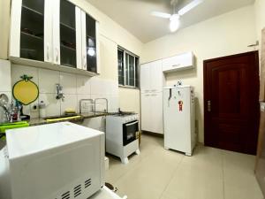 cocina con electrodomésticos blancos y nevera blanca en Apartamento quadra da praia de Copacabana, en Río de Janeiro