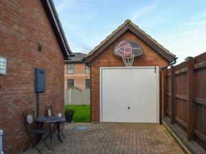 a basketball hoop attached to a brick building with a white garage at Autumn Lodge in Mablethorpe