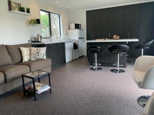 ein Wohnzimmer mit einem Sofa und einer Küche in der Unterkunft A Beauty on Bligh St Te Anau in Te Anau