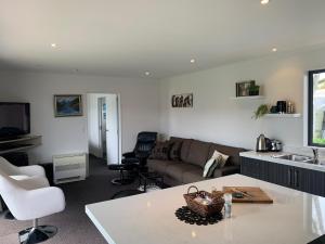 a kitchen and living room with a couch and a table at A Beauty on Bligh St Te Anau in Te Anau