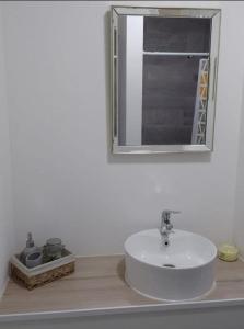 ロス・アンヘレスにあるDepartamento Los Canelos, a metros de Avenida Las Industrias, incluye aire acondicionadoのバスルーム(白い洗面台、鏡付)