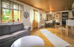 a living room with a couch and a table at Lovely Home In Rke With Wifi in Röke