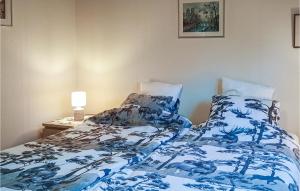 a bedroom with a bed with a blue and white comforter at Lovely Home In Rke With Wifi in Röke