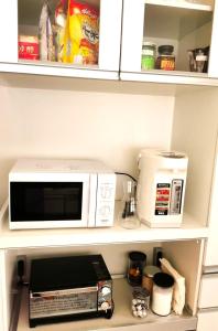 a microwave and a toaster oven on a shelf at Bell house in Tokyo