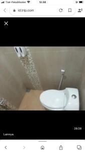 a bathroom with a white toilet in a room at Harys homestay in Triwung
