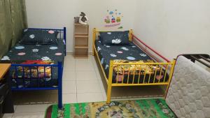 um pequeno quarto com uma cama e um beliche em illa Bella Homestay Jasin em Jasin
