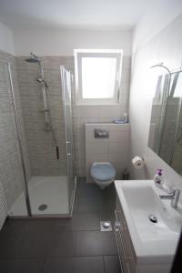 a bathroom with a shower and a toilet and a sink at Apartments Villa Mare in Krk