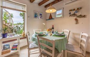 d'une salle à manger avec une table, des chaises et une fenêtre. dans l'établissement Cozy Apartment In Premantura With Wifi, à Premantura