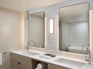a bathroom with a sink and a large mirror at Reef View Hotel in Hamilton Island