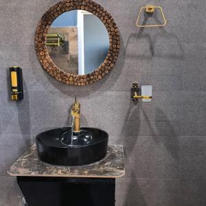 a bathroom with a black sink and a mirror at The Loft House in Dimāpur