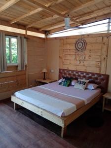 een slaapkamer met een groot bed en een houten muur bij Love Temple Beach Resort in Arambol