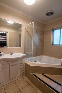 a bathroom with a tub and a sink at Albury Georgian Motel & Suites in Albury