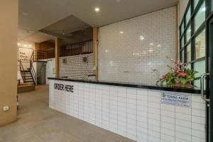 um restaurante com um balcão de azulejos brancos num edifício em RedDoorz Plus @ Cemara Asri Medan em Pulauberayan Dadap