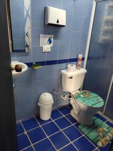 Baño de azulejos azules con aseo y lavamanos en Emily place 1 y 2 en San Andrés