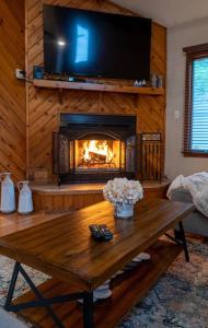 - un salon avec une cheminée et une table en bois dans l'établissement Charming Corner Newly Furnished Townhome, à Lake Harmony