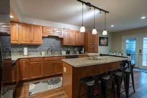 a kitchen with wooden cabinets and a island with bar stools at Charming Corner Newly Furnished Townhome in Lake Harmony