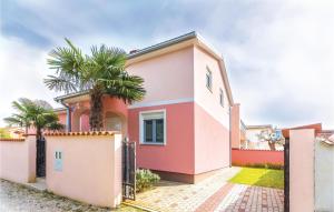 una casa rosa con una palmera en Stunning Home In Betiga With Kitchen, en Barbariga
