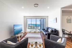 a living room with two couches and a television at The Shoal 503 Avra Seabreeze in Shoal Bay