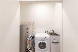 a laundry room with a washing machine and a sink at The Shoal 503 Avra Seabreeze in Shoal Bay