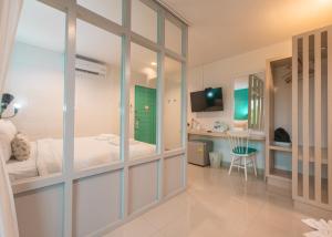 a bedroom with a bed and a desk in a room at Tiny Krabi Hotel in Ban Khlong Chi Lat