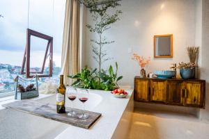 a bottle of wine and two glasses on a counter at Cherry Suites Dalat in Da Lat
