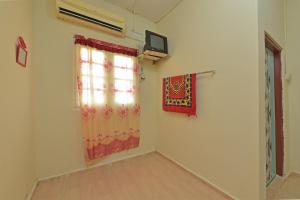 um quarto com uma janela e um quadro na parede em OYO 90689 Chalet Kak Siti em Kuala Terengganu