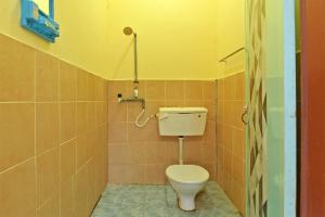 uma casa de banho com WC num quarto em azulejo em OYO 90689 Chalet Kak Siti em Kuala Terengganu