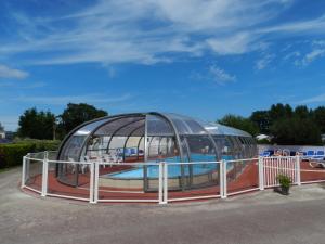 a water slide in a dome with a pool at Camping le Rivage in Quettehou