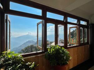 a room with windows with a view of a mountain at The Di-Lac Retreat in Gangtok