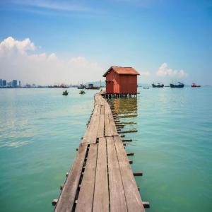 a dock with a red house in the water at The CEO Executive Suites in Bayan Lepas