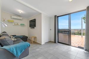 a living room with a couch and a sliding glass door at Barefoot Waters in Tailem Bend