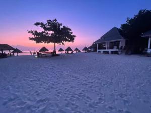 een strand met tenten en een boom op het strand bij Nice Sea Resort in Srithanu