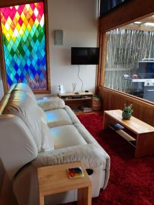 a living room with a couch and a stained glass window at Woodbridge Hill Hideaway in Woodbridge