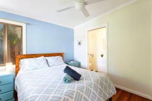 Un dormitorio con una cama azul y blanca y una ventana en Bella Lago - Peace and Tranquility by the Lake, en Smiths Lake