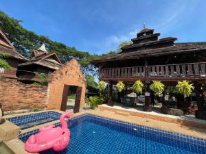 a pool with a pink flamingo in front of a building at Baan Tawai Lanna Resort in Hang Dong