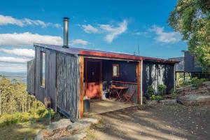 a small house on a hill with a table at Woodbridge Hill Hideaway in Woodbridge