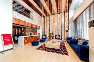 a lobby with a blue couch and chairs and a table at Hotel Divine Lakshmi Ganga in Rishīkesh