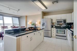 a large kitchen with white cabinets and appliances at 3/3 Condo on Texas Motor Speedway in Fort Worth