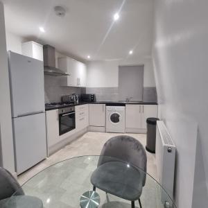 a kitchen with a glass table and a chair at 2 bed apartment in Plumstead London in Plumstead