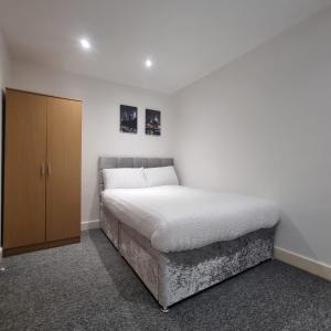 a bedroom with a bed and a wooden cabinet at 2 bed apartment in Plumstead London in Plumstead