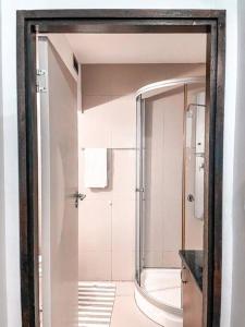 a bathroom with a shower and a glass door at City living near Nelson Mandela bridge in Johannesburg