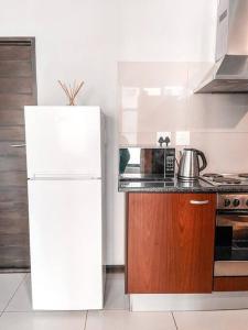 a kitchen with a white refrigerator and a stove at City living near Nelson Mandela bridge in Johannesburg