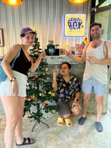 un grupo de personas de pie en frente de un árbol de Navidad en BeachBox@Koh Сhang, en Ko Chang