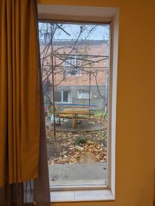 a window with a view of a bench in a yard at Berdo's Guest house in Sagarejo