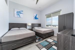 a bedroom with two beds and a television at AMAZING 2BR 2BA NEWLY RENO BEACHFRONT APT W/BEACH VIEW in Hollywood