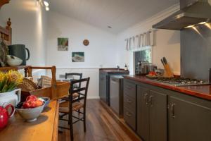a kitchen with a table with a bowl of fruit at Wild Orchid Olinda Private Luxury Cottage in Olinda