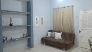 sala de estar con sofá marrón y ventana en Loft da Lily, en Natal